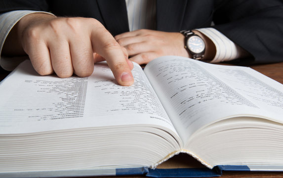 man looking in the large dictionary