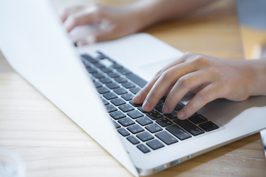 Closeup of business woman hand typing on laptop keyboard with mo