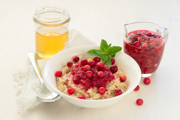 Oatmeal with cranberry jam, fresh cranberries and honey