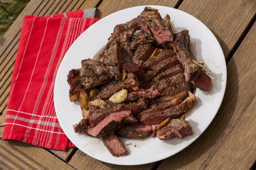Plate of Grilled Steak and Garlic with Red Napkin