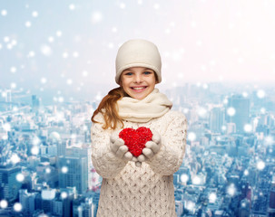 dreaming girl in winter clothes with red heart