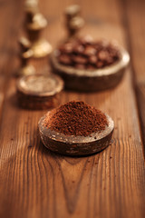 grated coffee in old iron weights and wooden  background