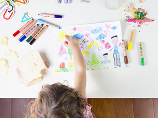 Little girl point at a sun in drawing of multi-racial Family