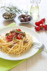 italian spaghetti pasta with cherry tomatoes, olives, capers and