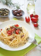 italian spaghetti pasta with cherry tomatoes, olives, capers and