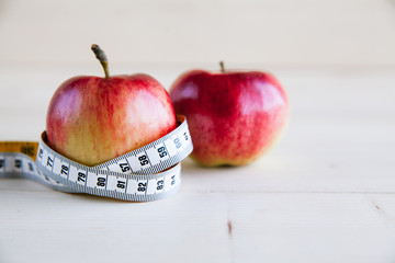 Diet concept with red apple and measuring tape