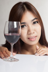 Beautiful Asian woman with red wine on white table