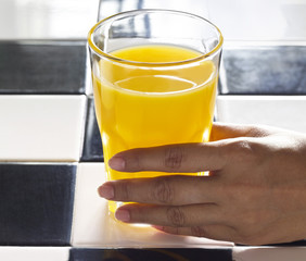 hand with orange juice in sunshine, realistic Atmosphere