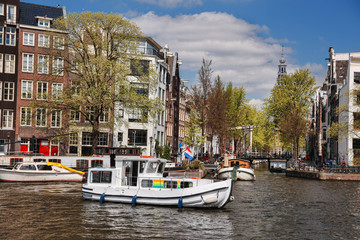 Fototapeta na wymiar Amsterdam city with boats on canal in Holland