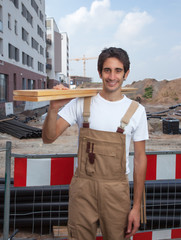 Lachender Schreiner mit Brettern
