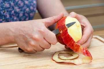 Hands peeling apple