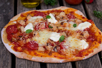 Homemade pizza with tomato sauce, tomatoes and mozzarella