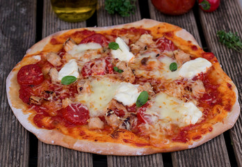 Homemade pizza with tomato sauce, tomatoes and mozzarella