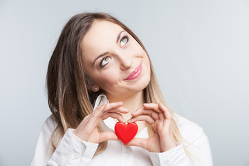 Portrait of a cheerful female holding a heart - 70751022