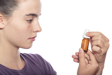 woman is examine a bottle of homeopathic medicine, isolated on w
