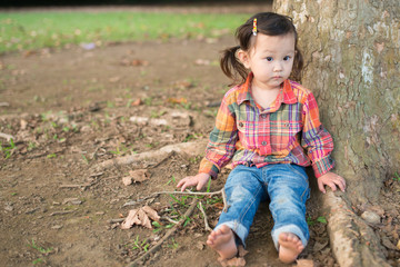 木に寄りかかる少女