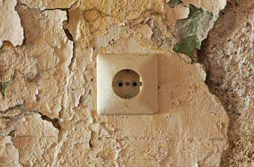 Old electrical outlet on decrepit wall