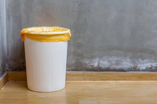 The white plastic bin with orange bag on wooden floor with expos
