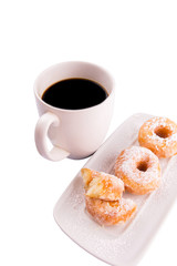 A mug of coffee and homemade doughnut with sugar toppings 