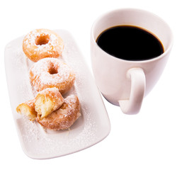 A mug of coffee and homemade doughnut with sugar toppings 