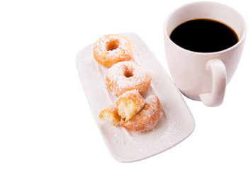 A mug of coffee and homemade doughnut with sugar toppings 