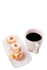 A mug of coffee and homemade doughnut with sugar toppings 