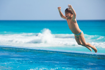 Jumping to the pool excited boy
