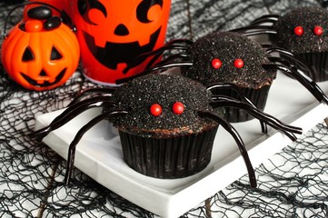 Spider cupcakes on a plate with Halloween decor