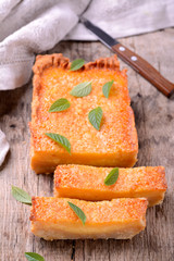 Homemade orange tart with mint on wooden background
