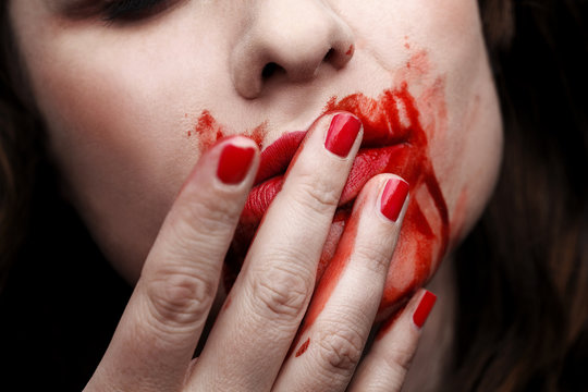 Female vampire licking blood off