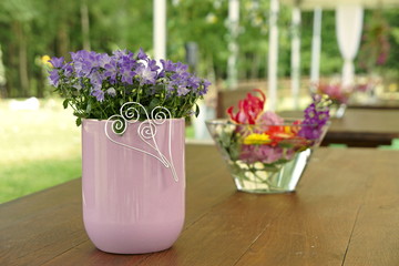 Wedding decoration on the table in nature - blue bells in a vase