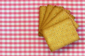 Classic crunchy biscuits on pink checkered cloth with copy space