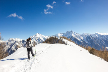 Ragazza ciaspola su cresta in montagna