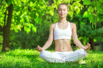 Naklejka na ściany i meble Yoga outdoors. Woman meditating in lotus position. 