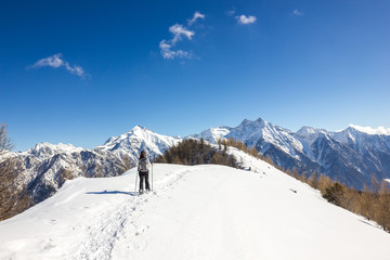 Ragazza ciaspola su cresta in montagna