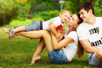 Happy young family is having fun in the summer park 