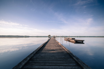 Fototapeta na wymiar Wooden pier in a lake. Sunrise at Soustons, France