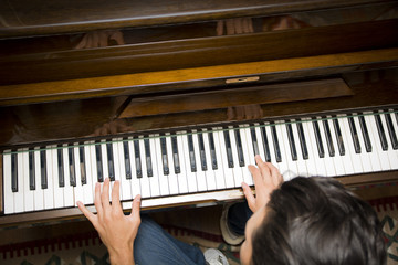 Fototapeta na wymiar Male hands playing piano indoors