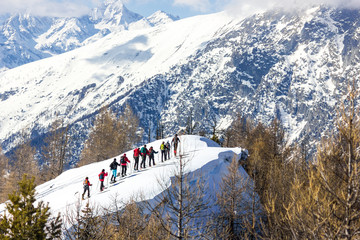 Gruppo di persone ciaspola in montagna