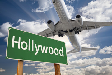 Obraz premium Hollywood Green Road Sign and Airplane Above