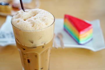 Iced coffee with rainbow crepe cake on a wooden table (Iced Capp