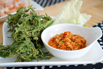 Thai chilli spicy sauce with fried and fresh vegetables on white