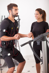  Female coach giving man ems electro muscular stimulation exerci