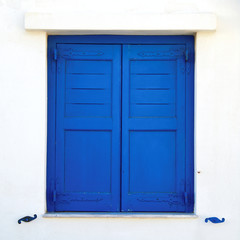 Greece, blue painted window shutters on white wall