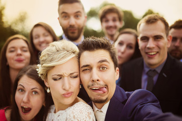 Newlyweds with friends taking selfie
