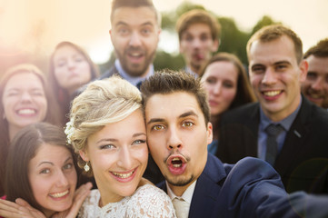 Newlyweds with friends taking selfie