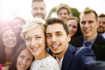Newlyweds with friends taking selfie
