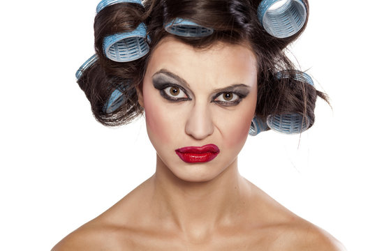 Funny girl with curlers and bad makeup with questionable gesture