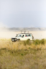 Obraz na płótnie Canvas Safari tourists on game drive in Serengeti