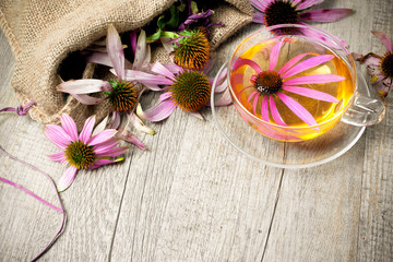 Cup of echinacea  tea on wooden table - obrazy, fototapety, plakaty